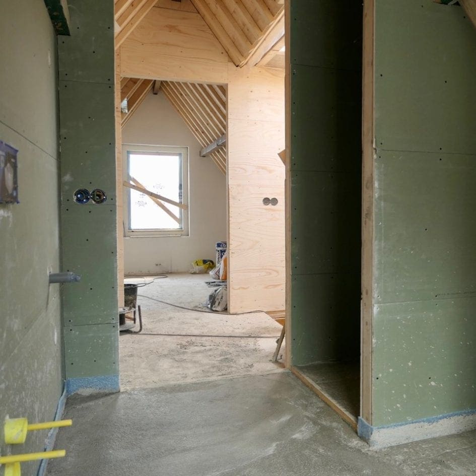 Op de voorgrond een deel van de badkamer met rechts de ingang van de inloopdouche.